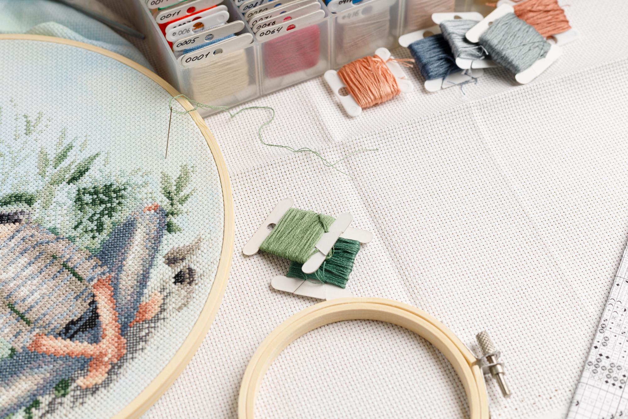Workshop table with threads, hoop and digital pattern